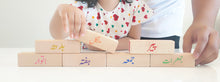 Load image into Gallery viewer, Child playing with urdu blocks. Urdu blocks colours and days of the week.
